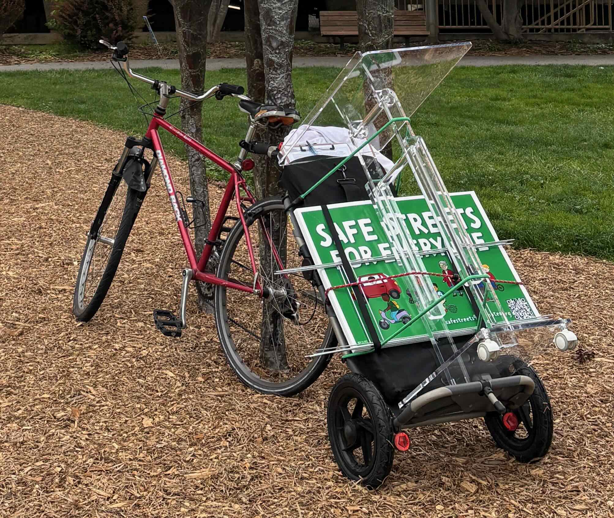 Red bike with Travoy carrying Safe Streets signage