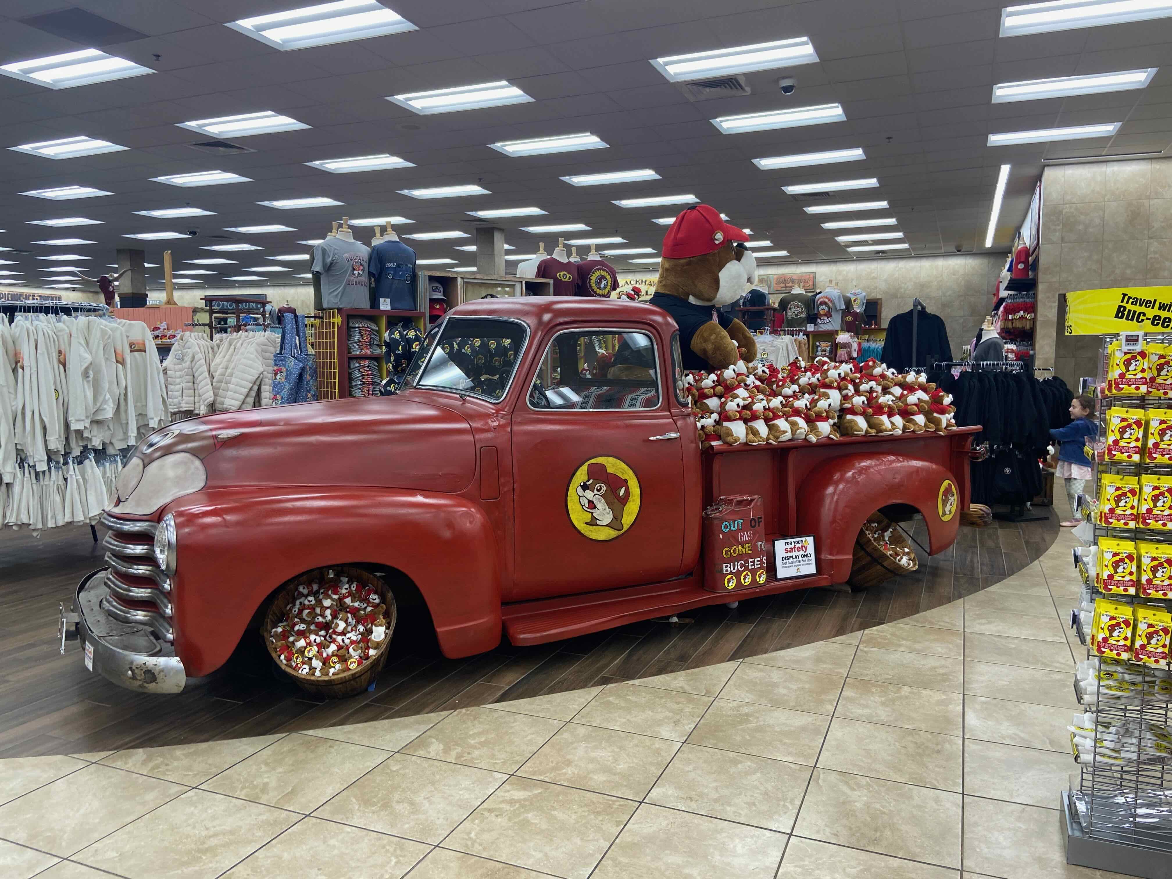 PHOTO: Vintage red Chevrolet pickup truck loaded with plush beaver stuffed animals, "Out of Gas? Gone to Buc-ee's" sign on the door