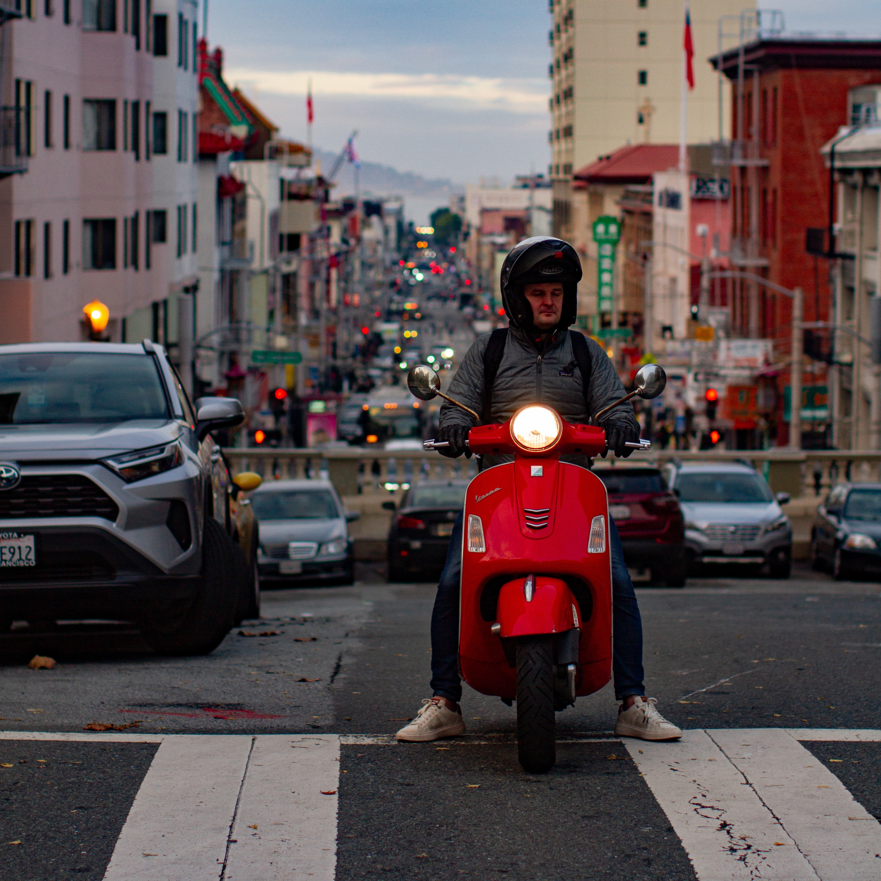 a male Vespa rider kitted out with his eyes closed