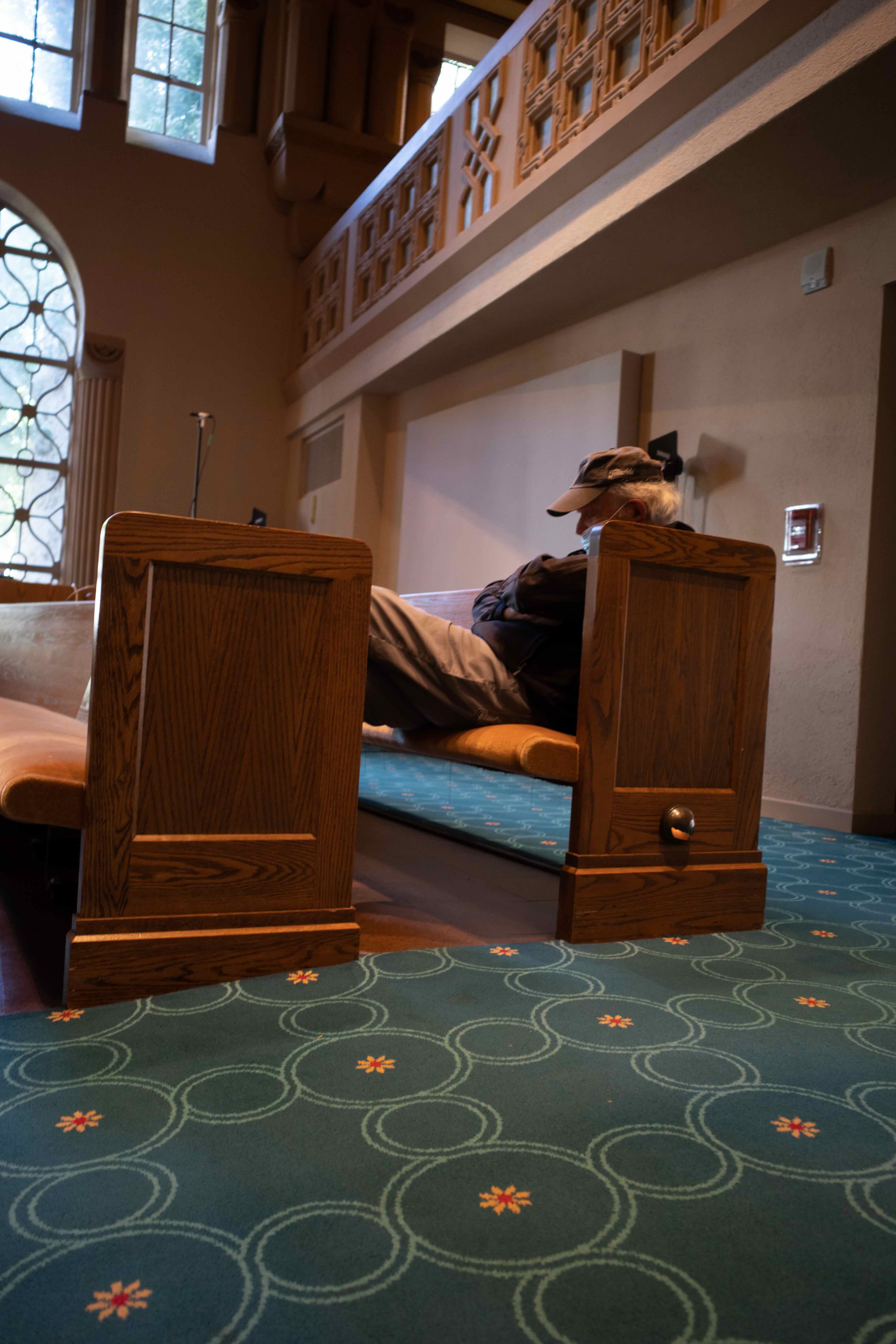 man sleeping in temple pew