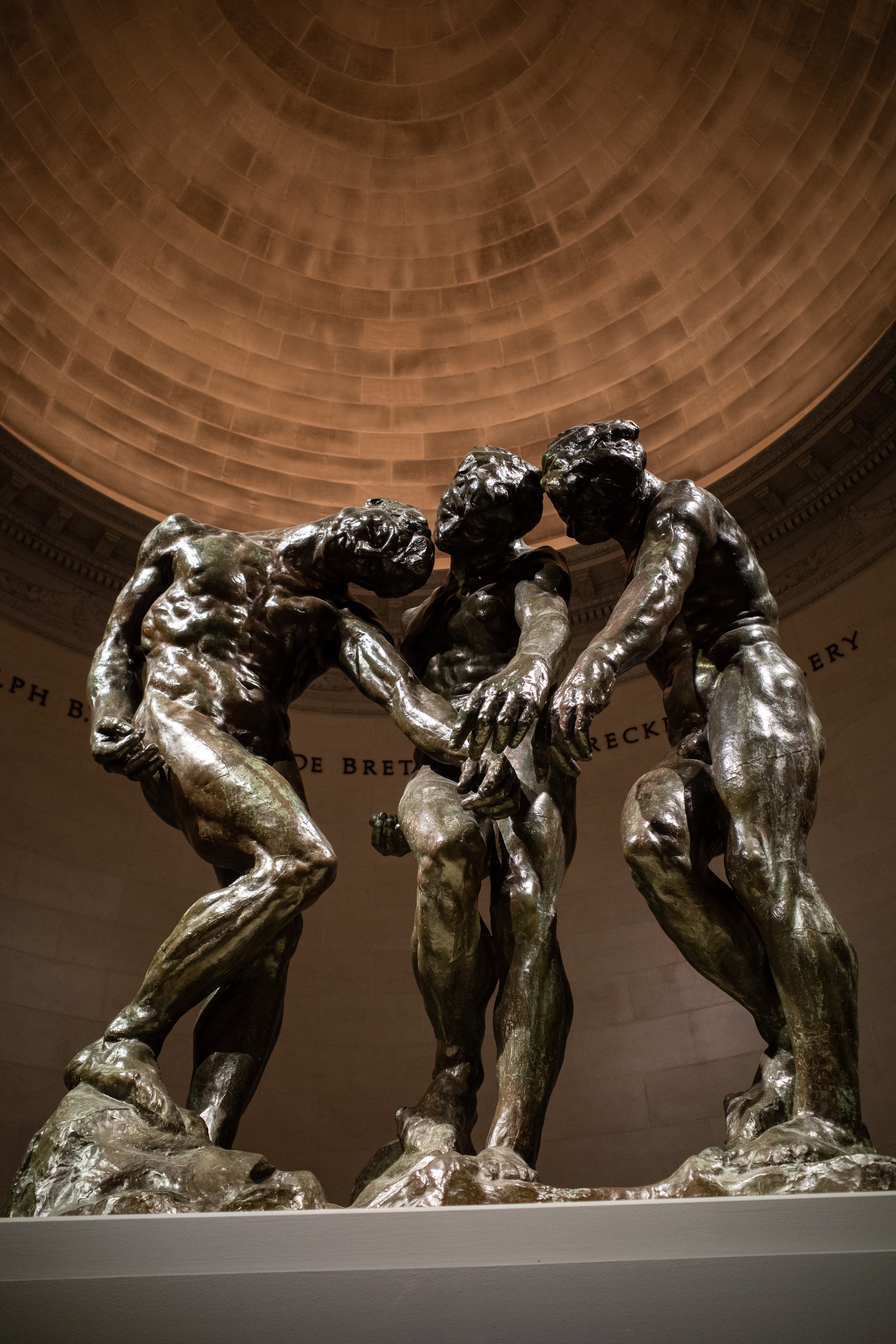 A trio of sculpted men pointing down