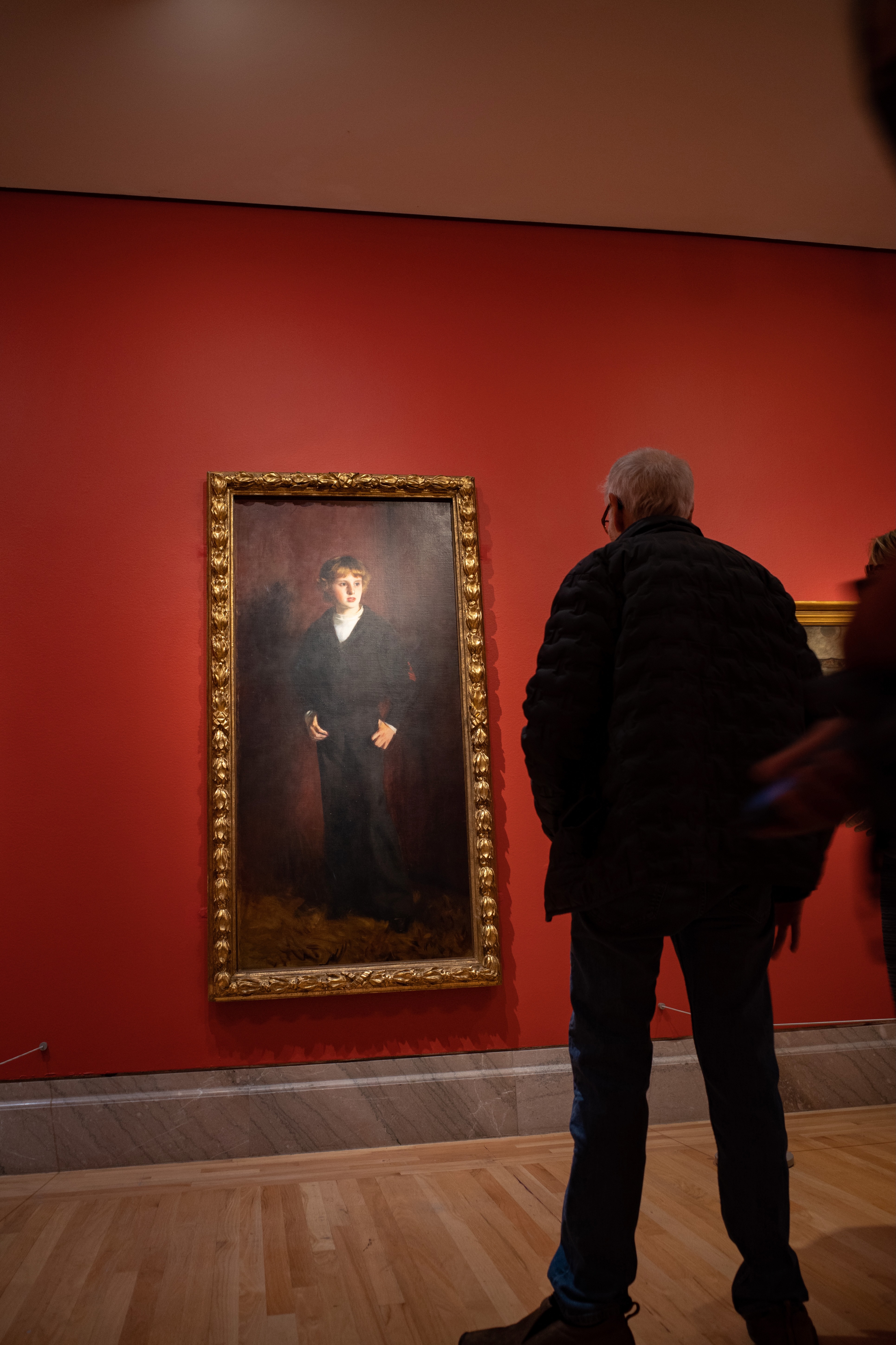 Art gallery staredown between old man and painting of young man