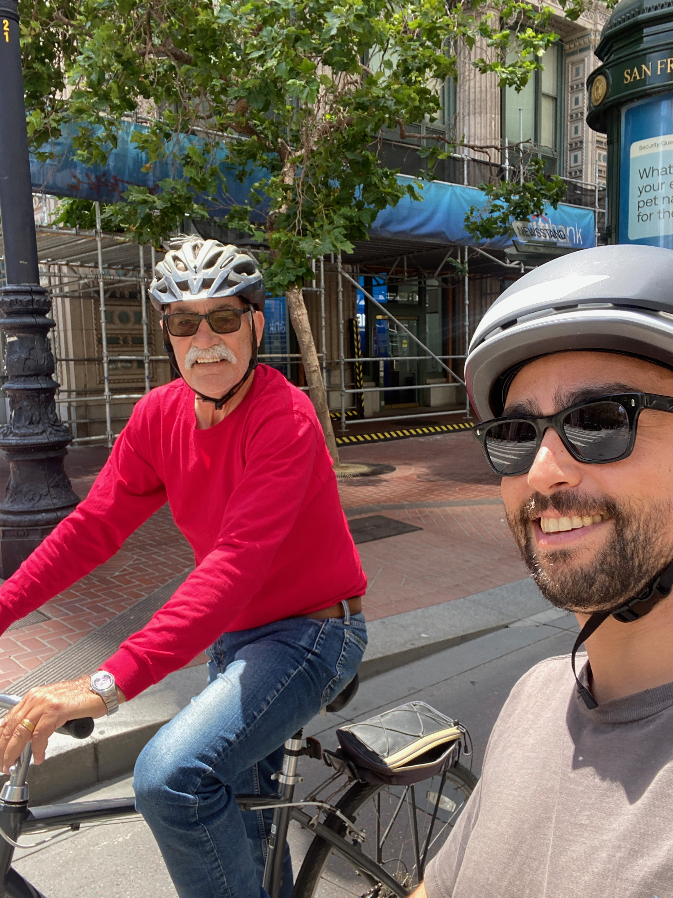 Mike & Max biking on Market Street in San Francisco, wearing helmets