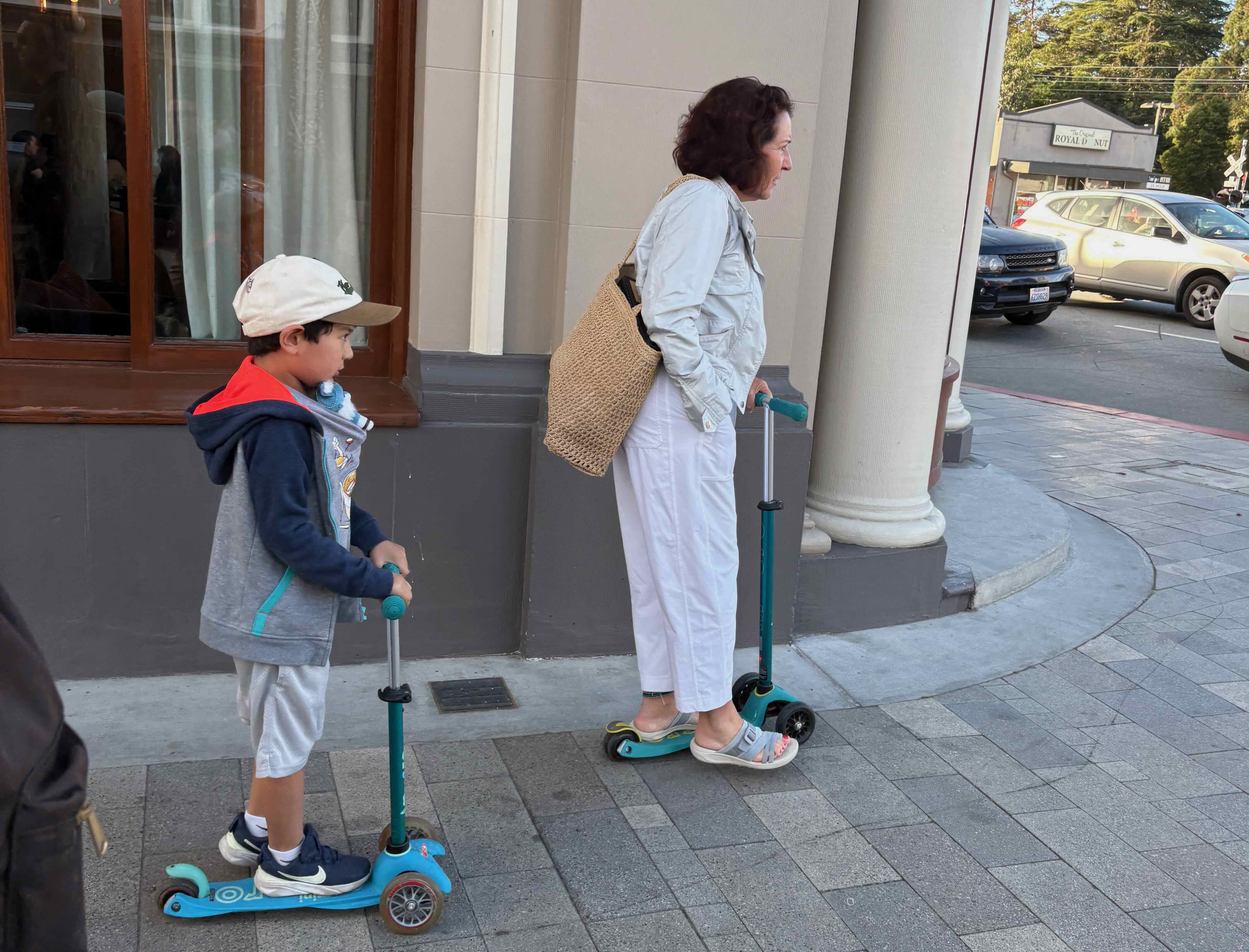 a grandmother and grandson riding 3-wheel kickscooters in Burlingame, CA