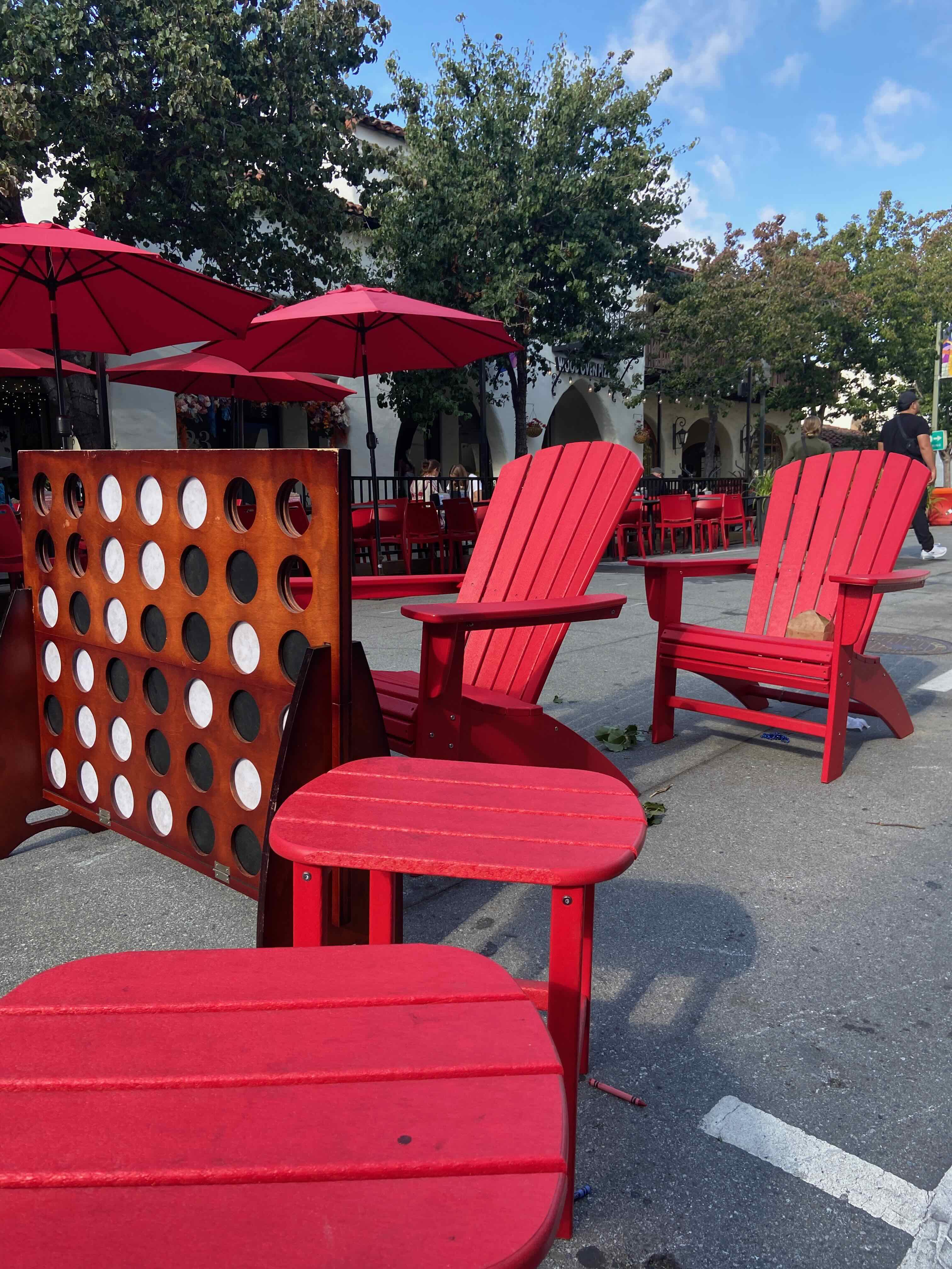 Red Adirondack chairs and a giant Connect 4 game on a closed street in Southern California