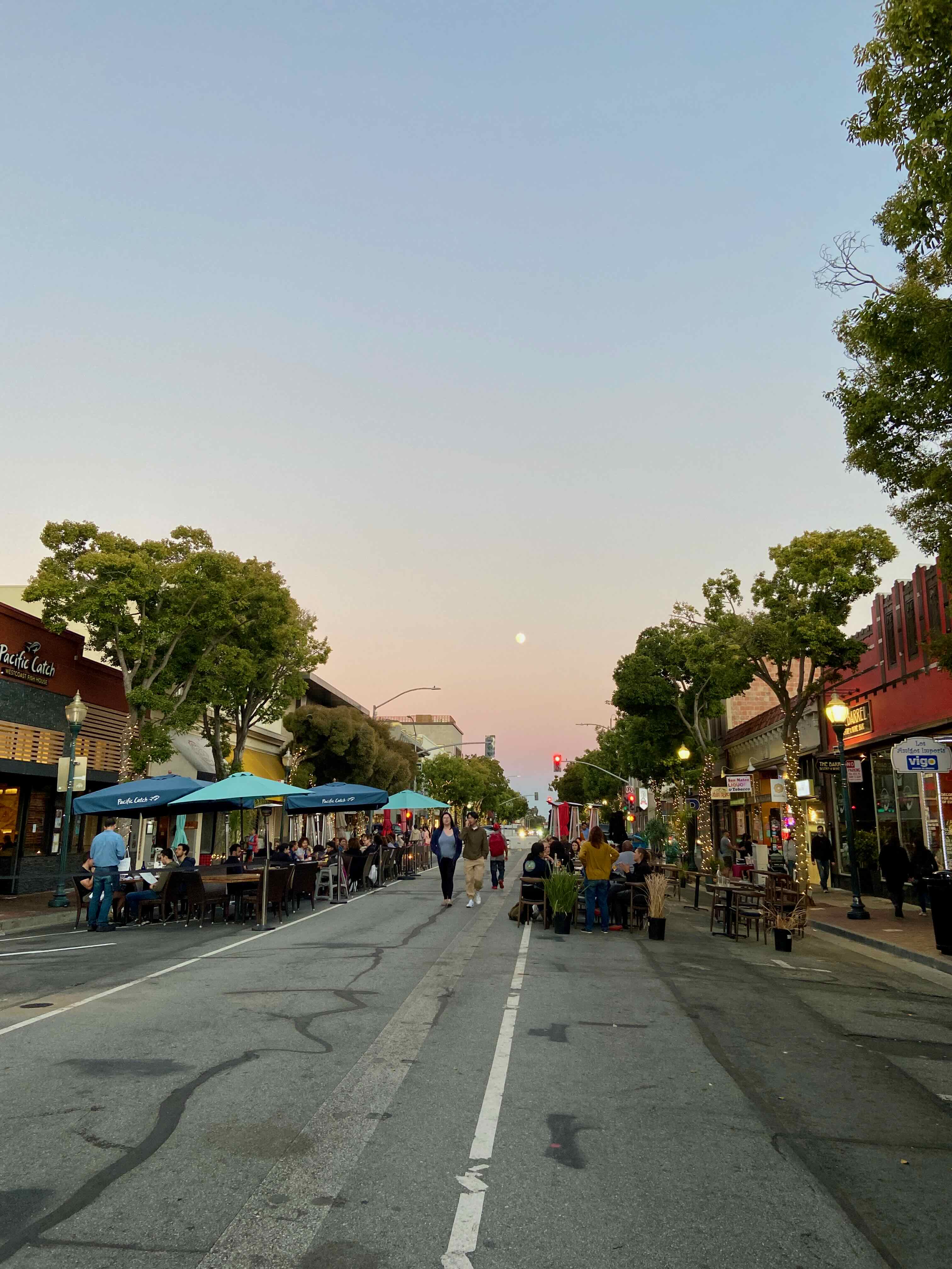 B Street in San Mateo before the mural, at dusk with a full moon, Pacific Catch umbrellas and diners visible