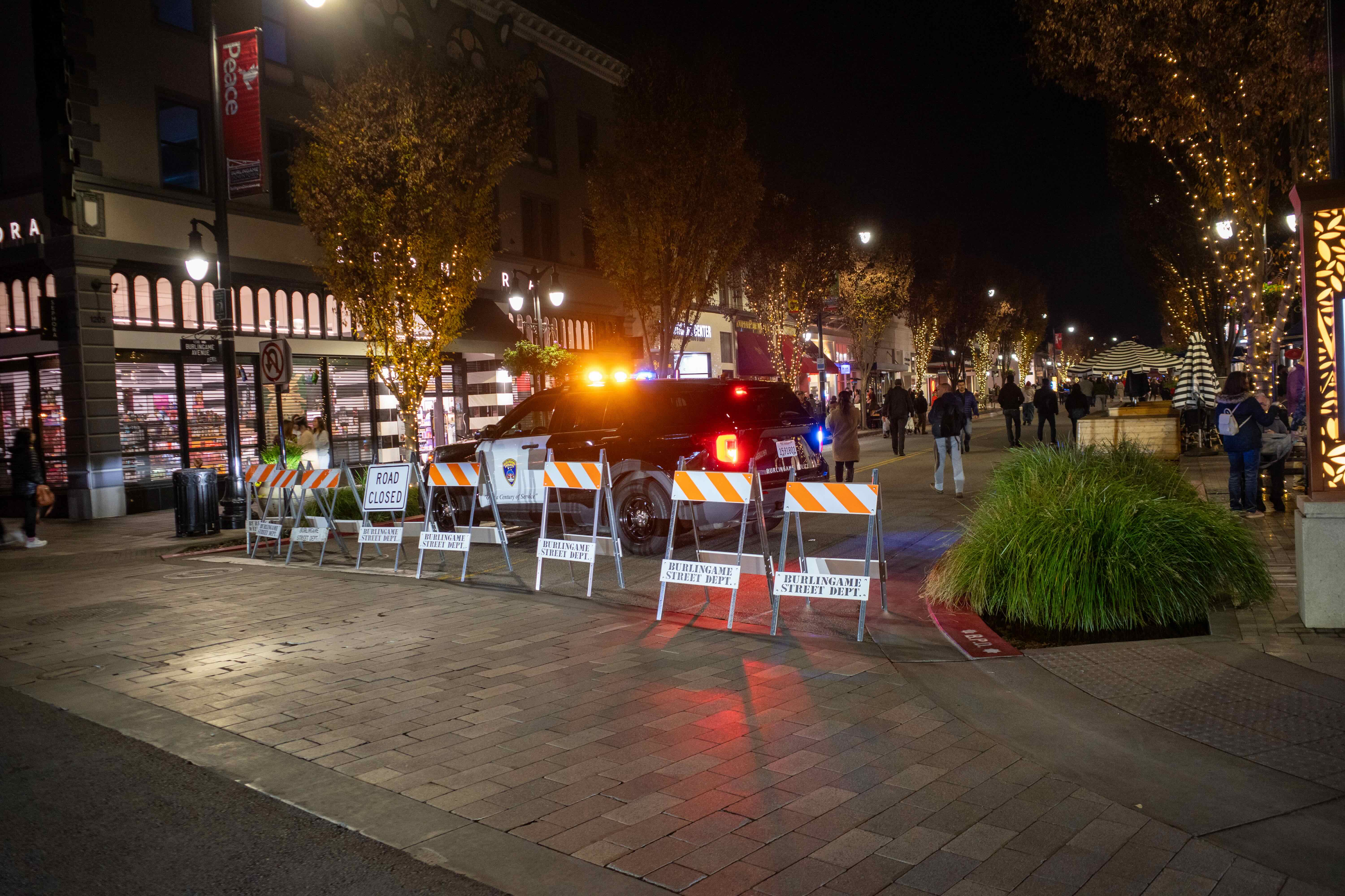 Orange barricades and a police car closing off Burlingame Avenue