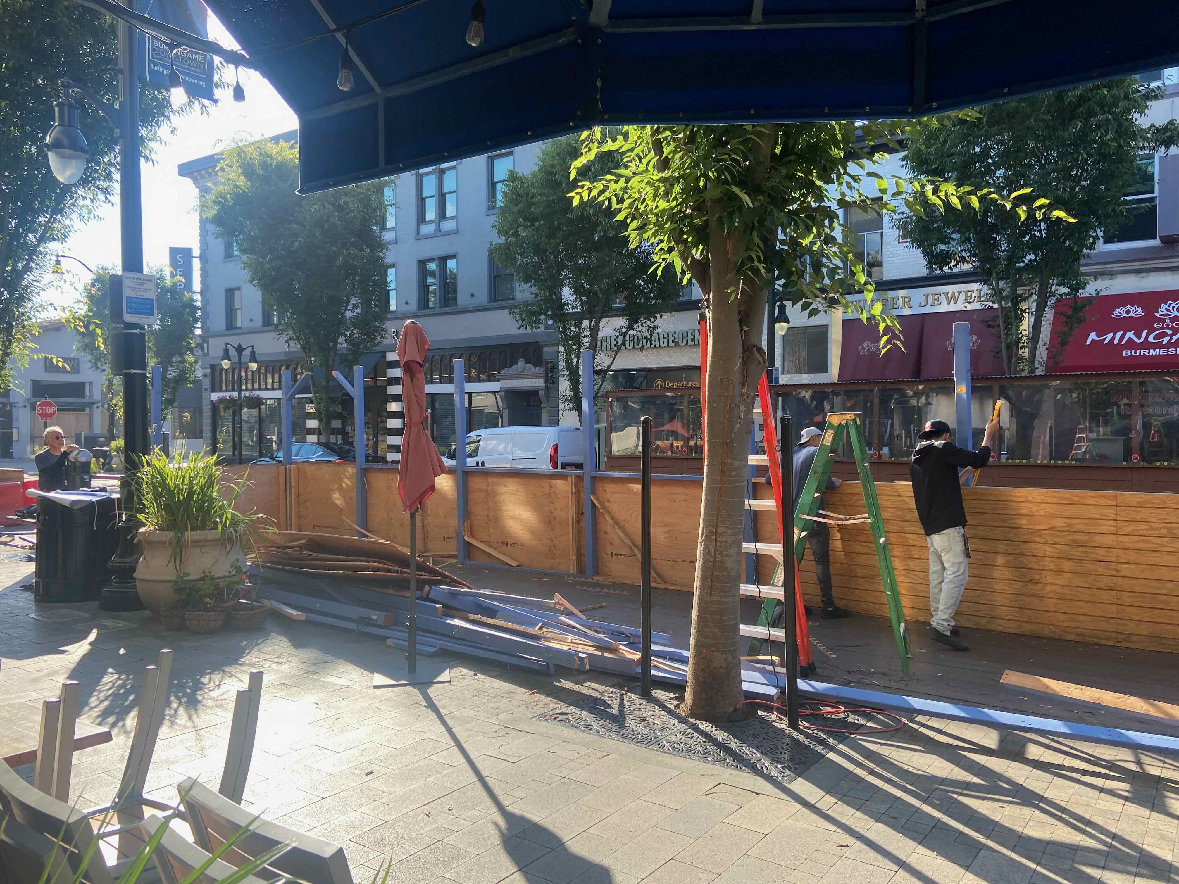 Workers dismantling a COVID-era parklet on Burlingame Avenue