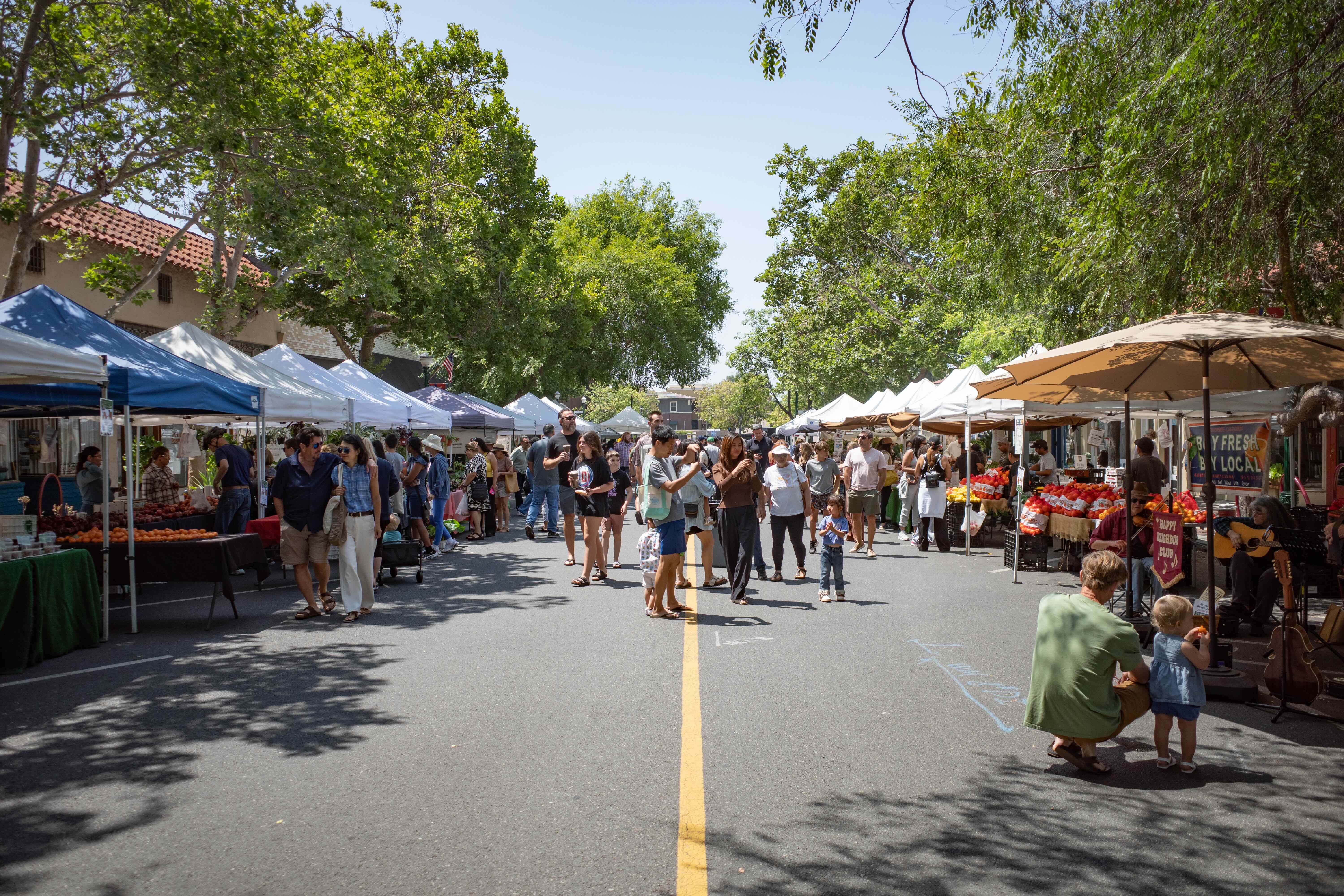 A Cool Zone misting tent at the Claremont farmers market with a large crowd