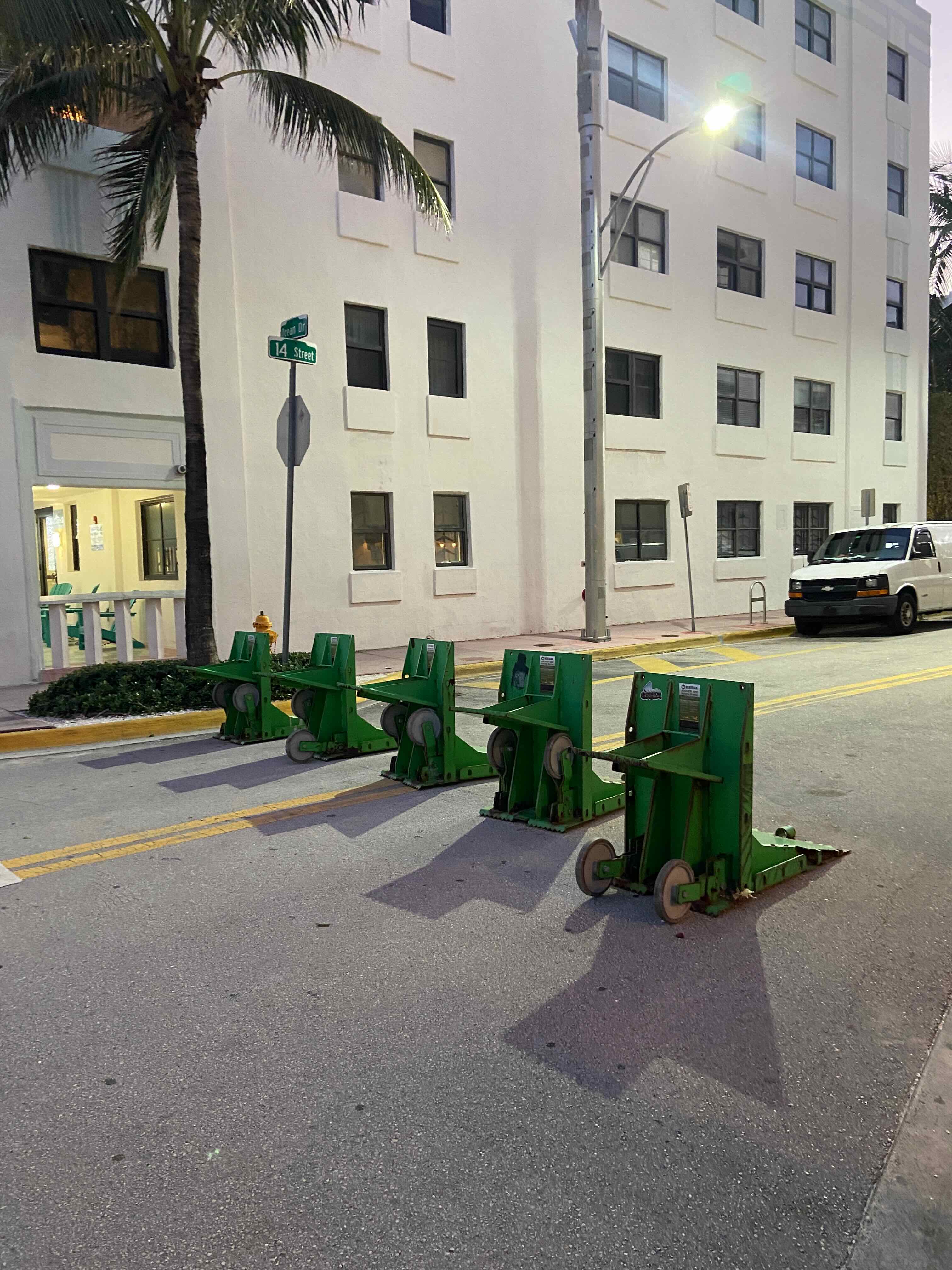 Green plastic jersey barriers blocking Ocean Drive in Miami Beach at dusk