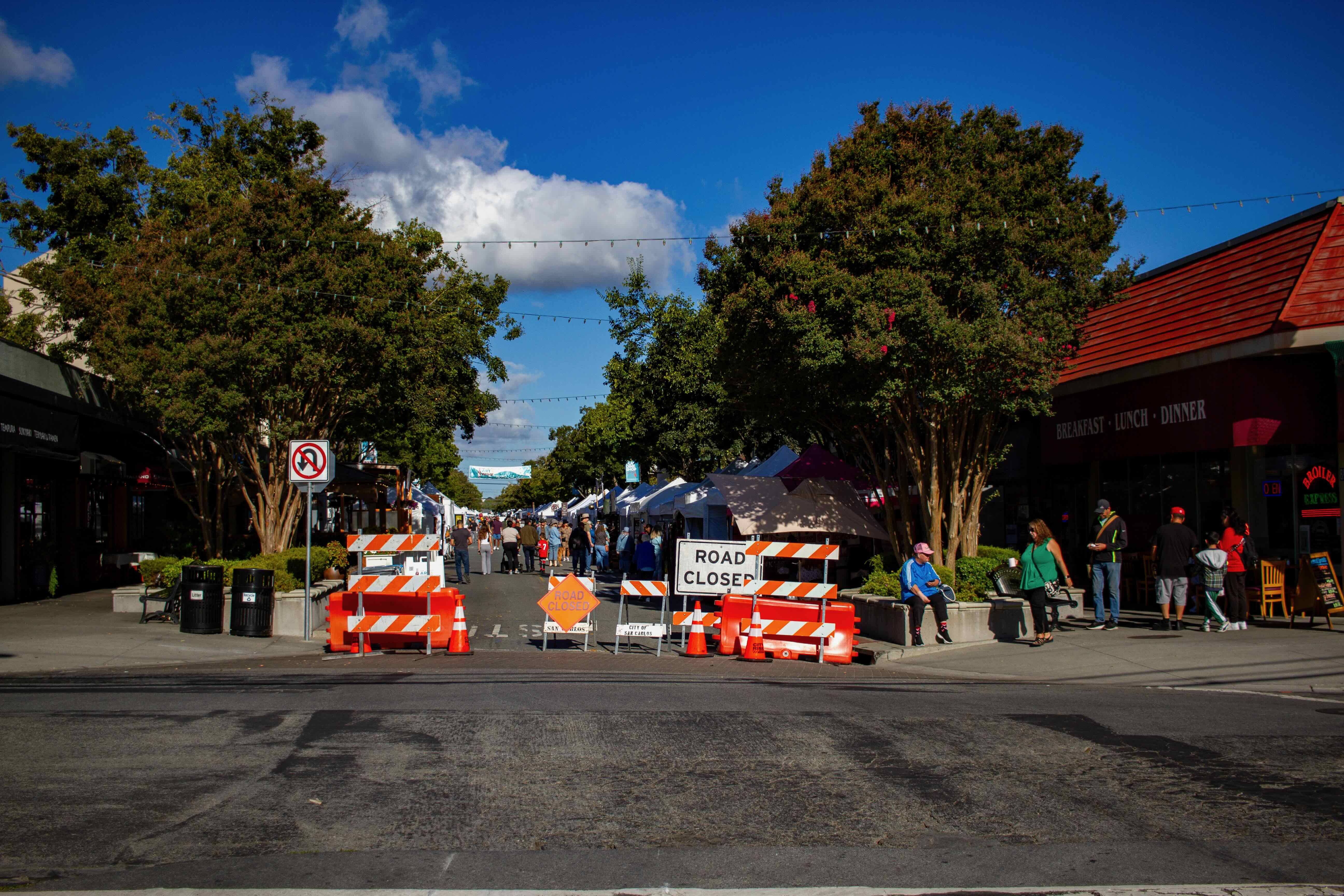 Orange road closed barricades at the entrance to the San Carlos farmers market on Laurel Street