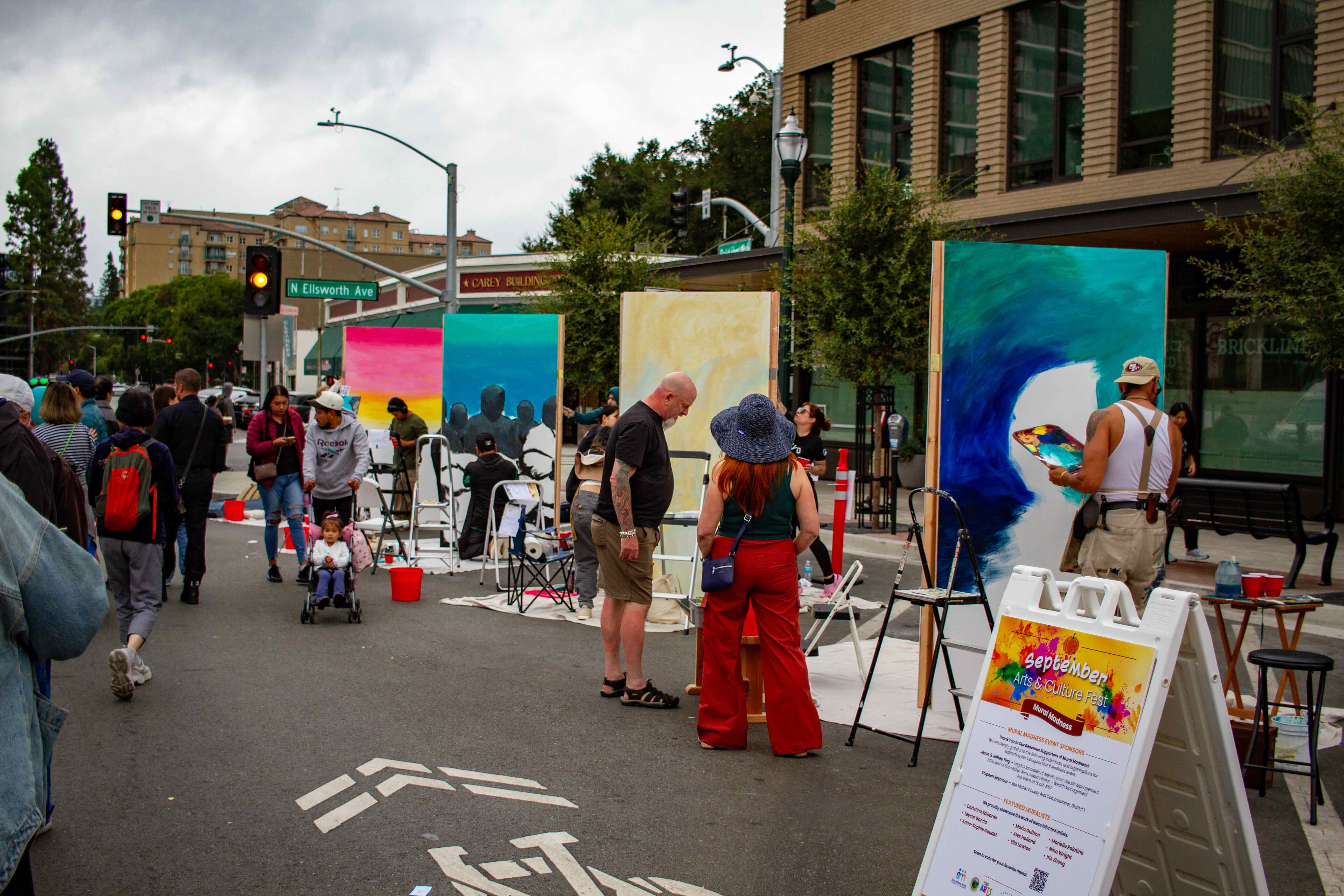 Artists participating in a pop-up art contest on a San Mateo street intersection