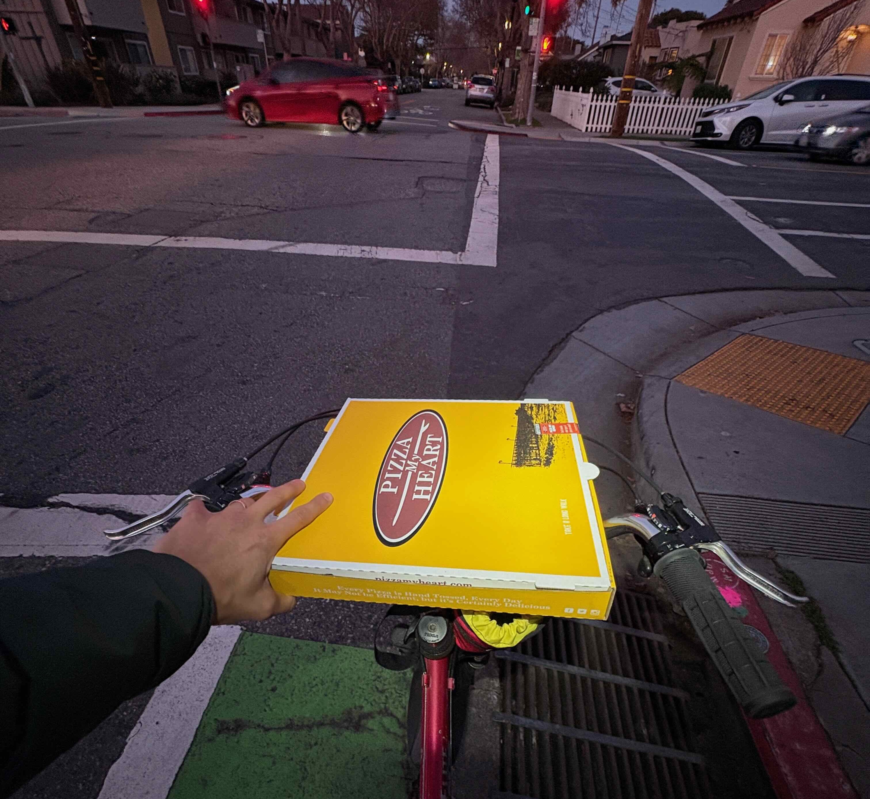 Picking up pizza by bike on a San Mateo bike lane at dusk