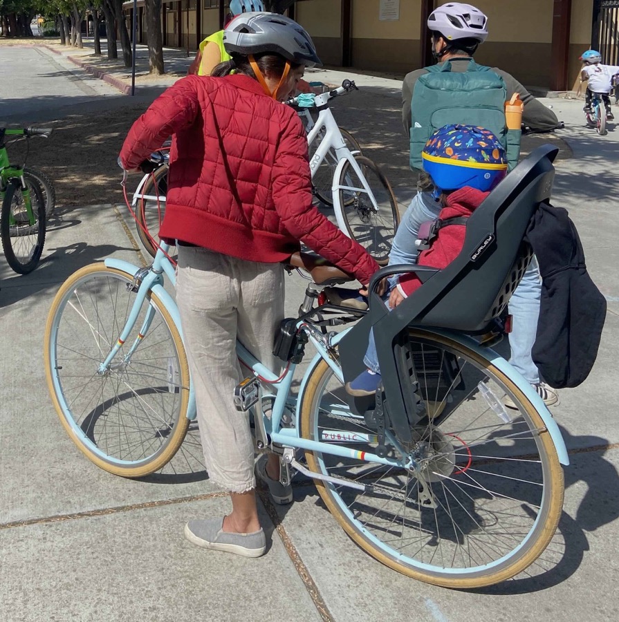 A child seated in a rear-mounted child seat on a bicycle, helmeted
